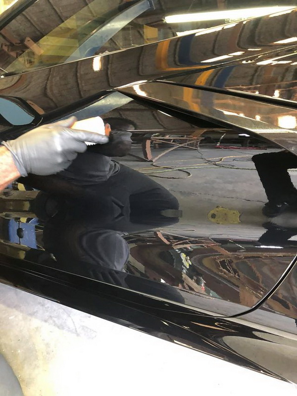 restoration shop applying coating to black camaro